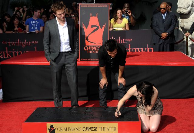Robert Pattinson y Taylor Lautner miran como firma Kristen Stewart